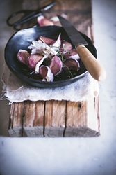 Garlic cloves in peel in bowl with knife