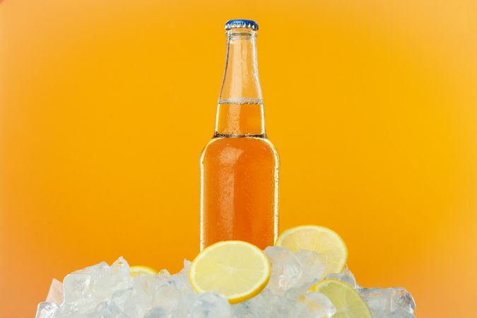 Bottle full of orange liquid on orange background