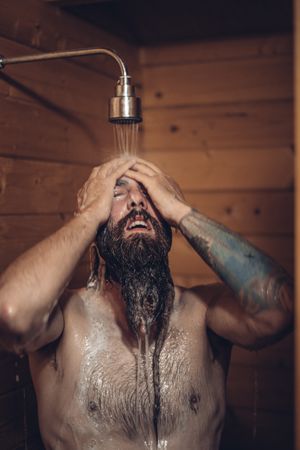 Man taking shower in wooden bathroom