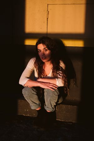 Smiling woman sitting in spot of light