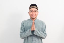 Asian Muslim man smiling doing greeting pose during Ramadan