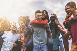 Group of young friends of different races and cultures having carefree fun together outdoors