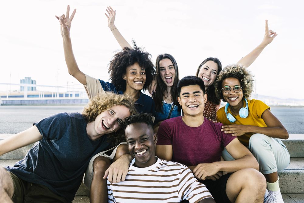 Portrait of diverse college friends sitting on city stairs