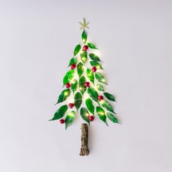 Christmas tree topped with star with lights made of leaves, berries and branch