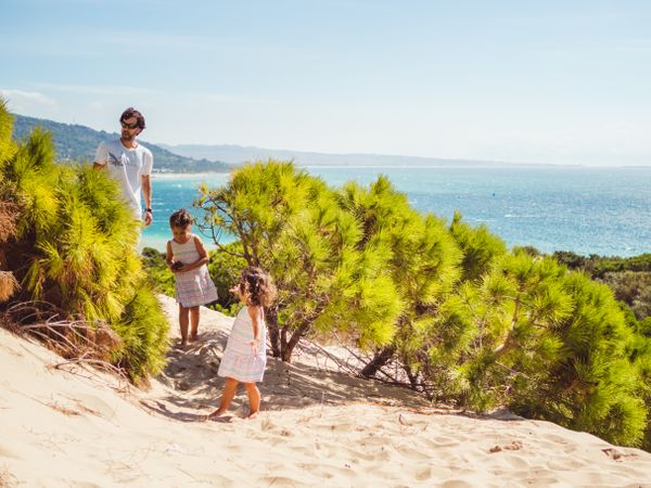 father with children having a stroll at beach