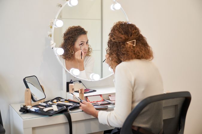 Concentrated woman doing makeup in beauty salon