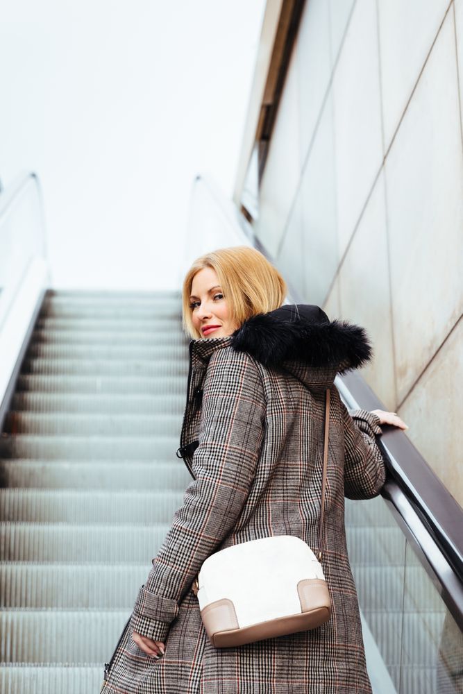 Blonde woman climbing escalators