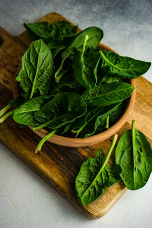 Bowl of fresh spinach on kitchen counter with copy space