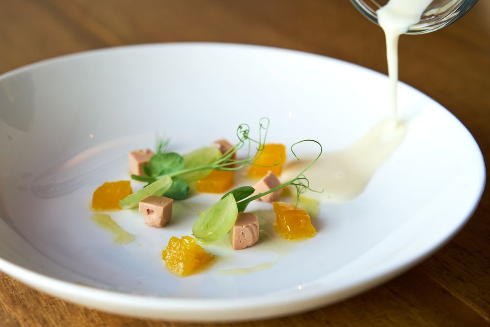 Celery cream in a jar poured into a plate with decorative ingred