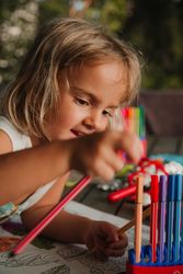 Girl coloring pictures at home