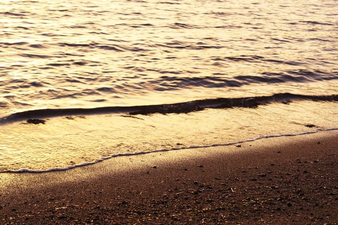 Idyllic seashore with waves in sunset
