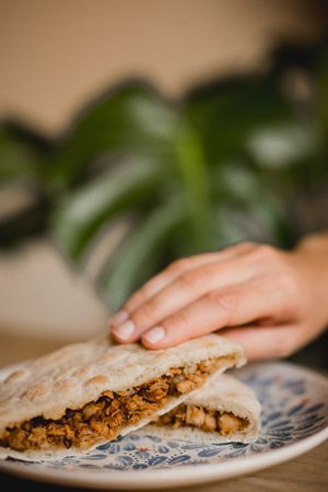 Hand holding hot delicious Chinese burgers in Asian restaurant