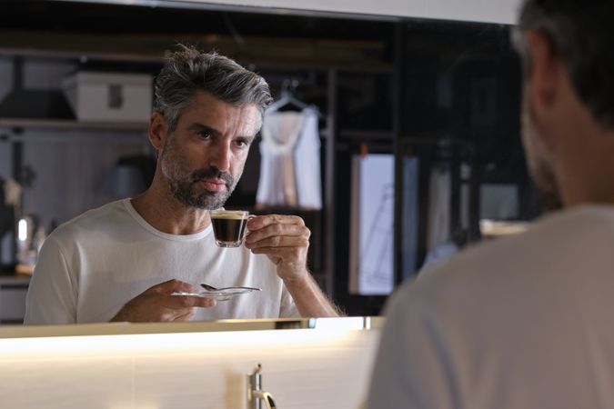 Confident male looking at reflection in mirror