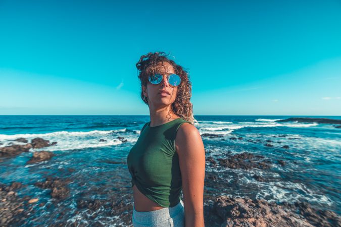Stylish woman standing near sea