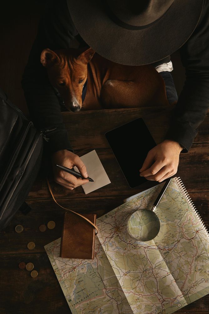Top view adventure traveler in wide hat writing at desk