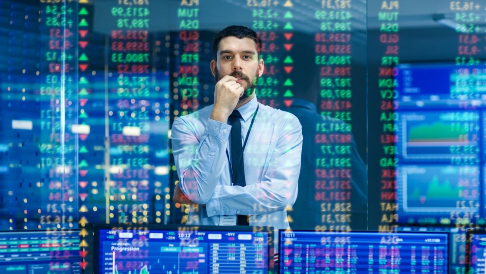 Stock Market Top Trader Looks at Projected Ticker Numbers and Graphs Running, Analysing Data to Make Best Sell.