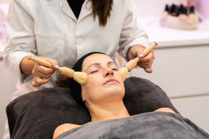 Woman having relaxing facial with brushes