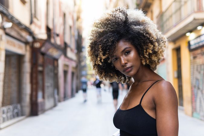 Black woman standing on street looking at camera