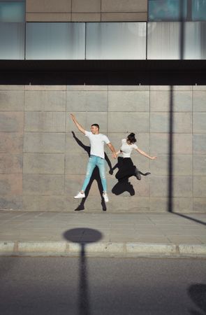 Couple jumping for joy in the streets.