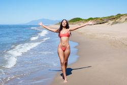 A Joyful Woman Blissfully Enjoying a Beautiful and Relaxing Day at the Sandy Beach Location