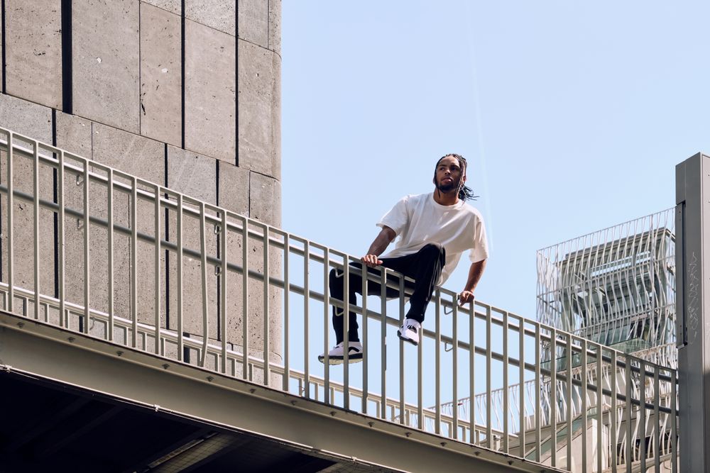 Black male sitting on bridge