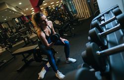 Woman lifting dumbbells on bench