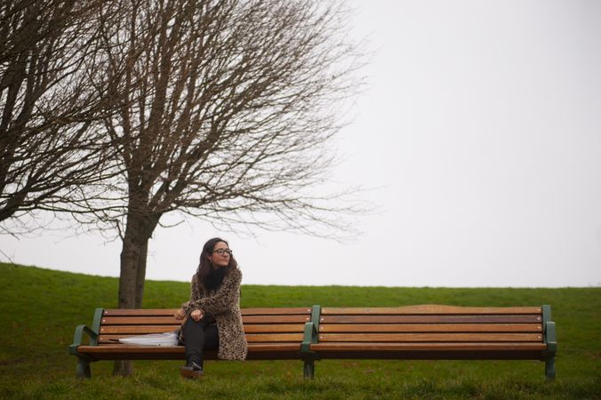 Woman on bench in foggy park
