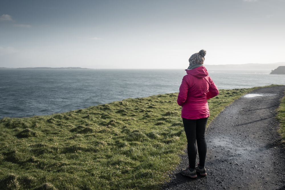 Woman standing on country road admiring views