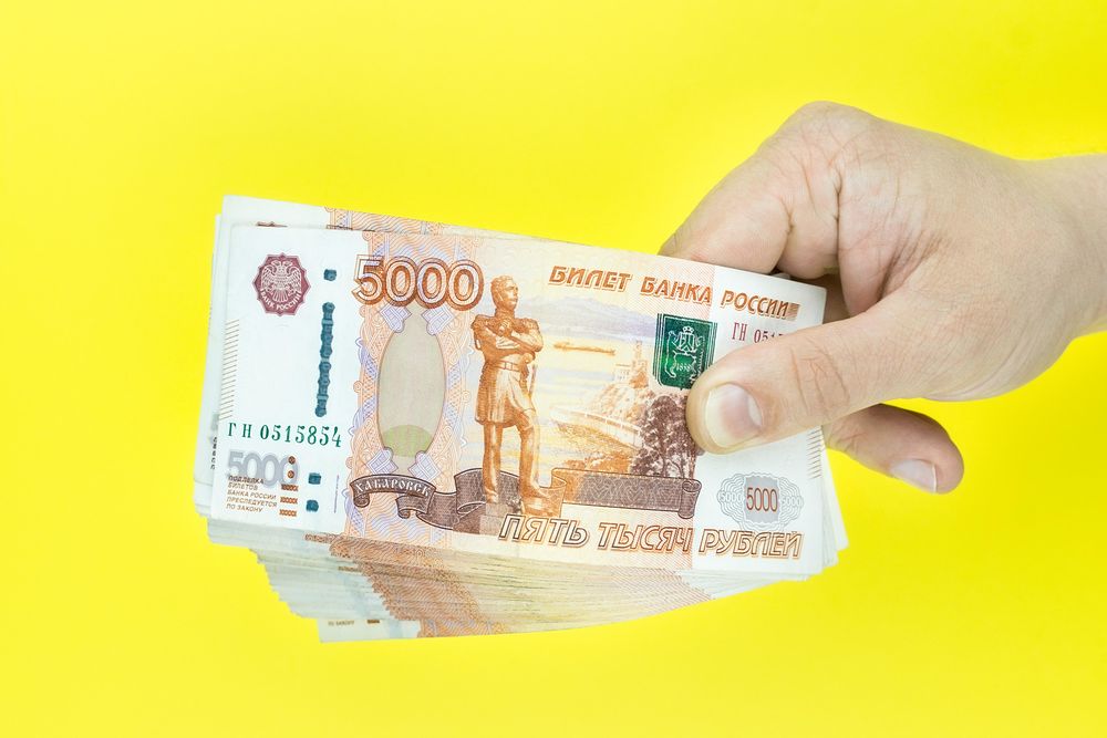 Man holding 5000 Russian Rubles
