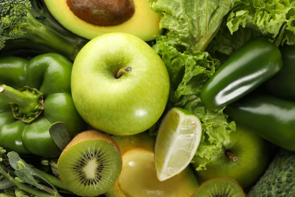 Green vegetables and fruits on whole background