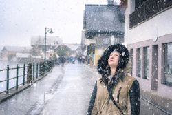 Happy woman looking up at snowflakes