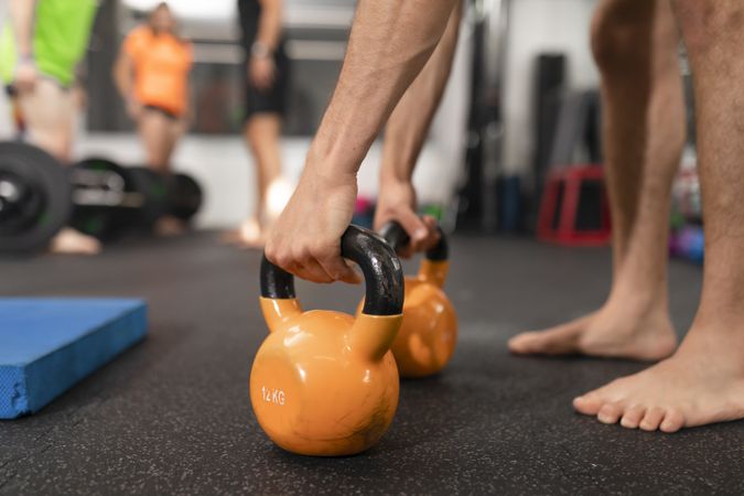 Close up of a pair of kettlebells being grabbed