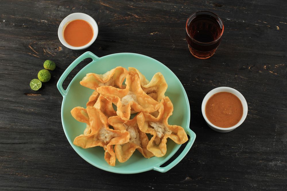 Plate of deep fried wonton snacks on dinner table