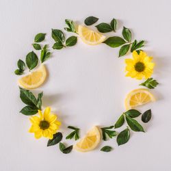 Round wreath of yellow flowers lemon slices and leave