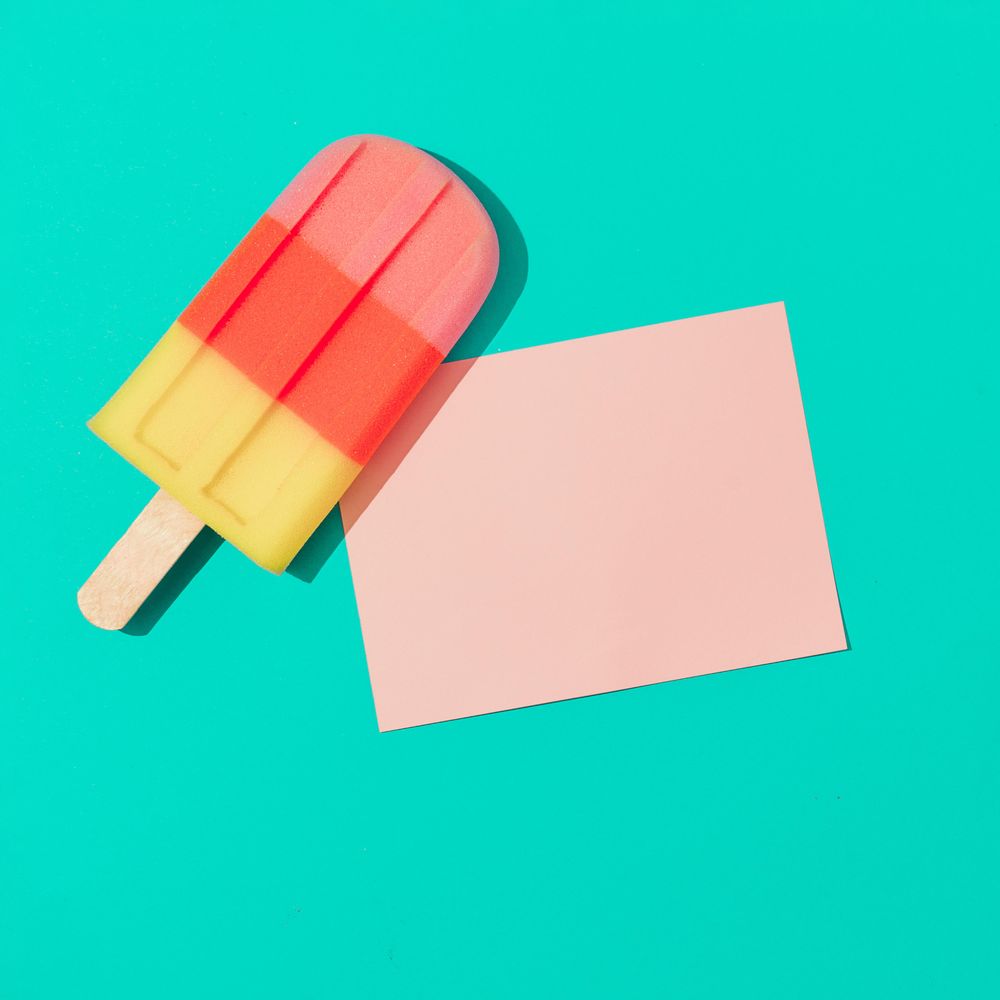 Ice cream popsicle with pink paper card note on vivid blue background