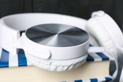 Concept of audiobook with book and headphones, close up