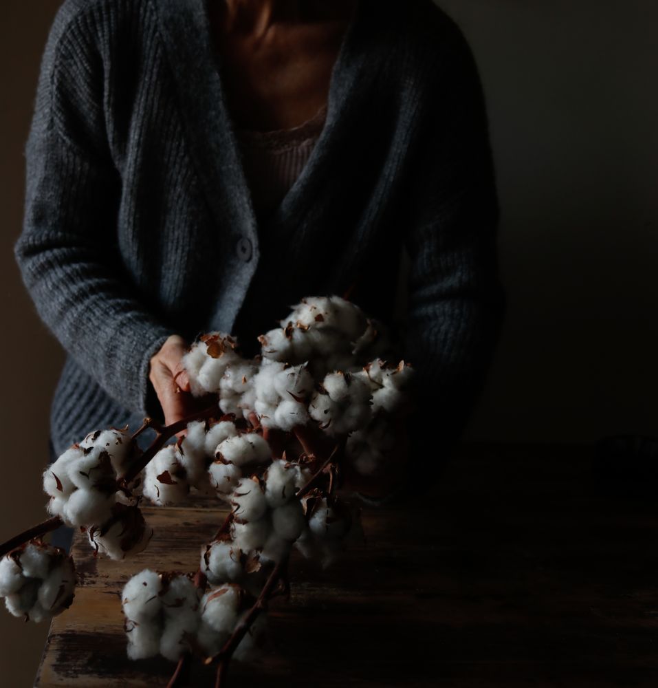 Crop woman with cotton twigs
