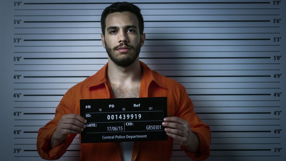 In a Police Station Arrested Man Getting Front-View Mug Shot.