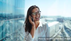 Beautiful woman talking on cell phone in high-rise office building 5q1dw5