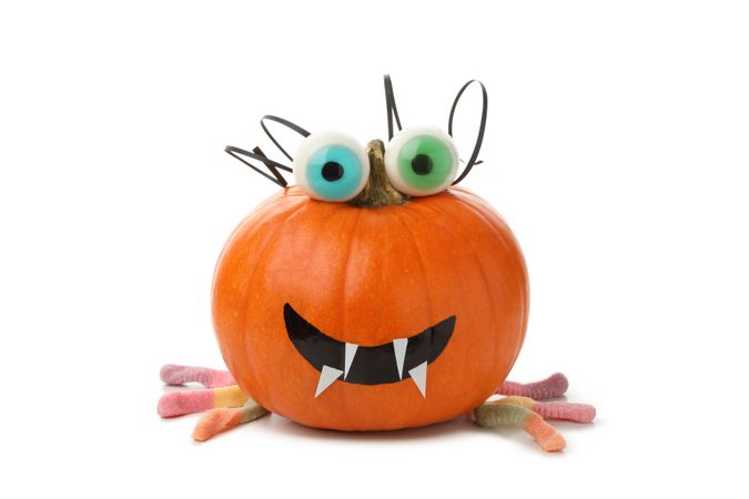 Decorated pumpkin with candy eyes isolated on blank background