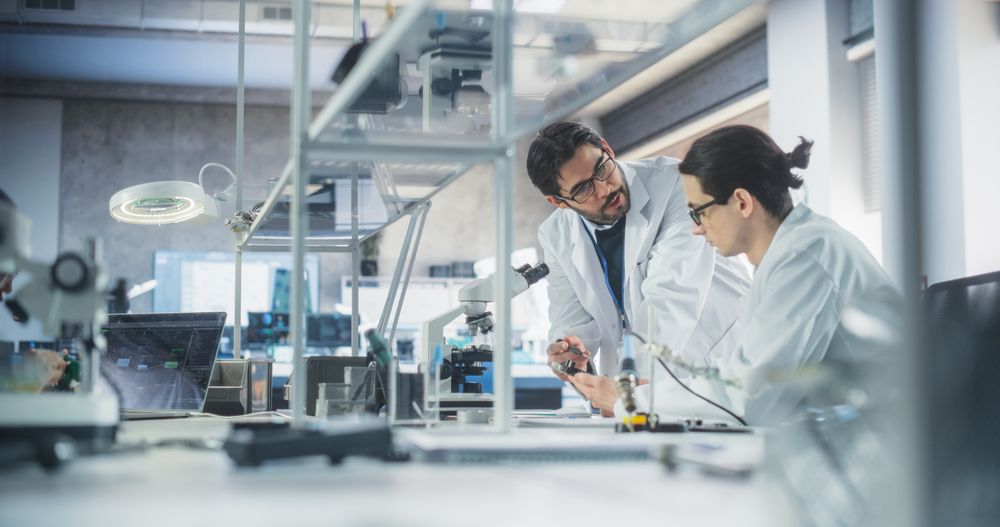 Young Man Having a Conversation with a Science Teacher in a Laboratory.