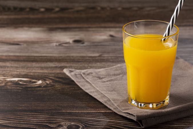 Glass with orange juice on the table.