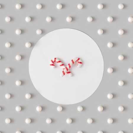 Holiday pattern with candy canes and snowballs on gray background