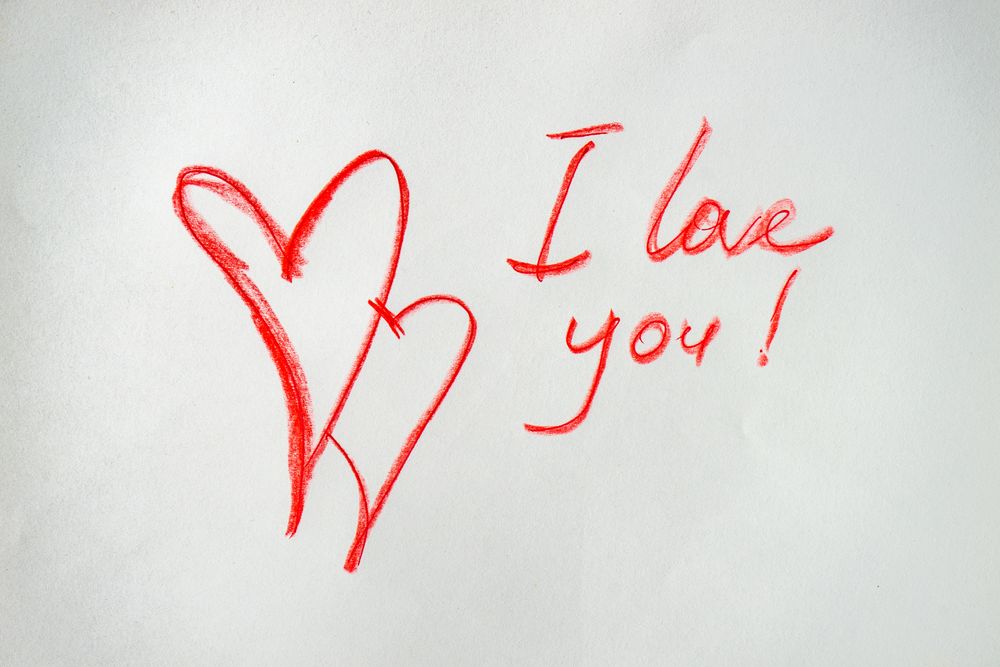Valentine Day holiday card concept with "I love you" and two hearts drawn in red