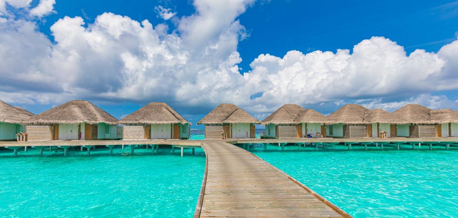 Pedestrian walkway over water leading to beach holiday villas