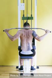 Back of tattooed male using weight machine 4j2KR4