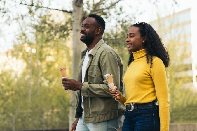 Black couple eating ice cream in a park