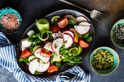 Plate of delicious vegetable salad on rustic background