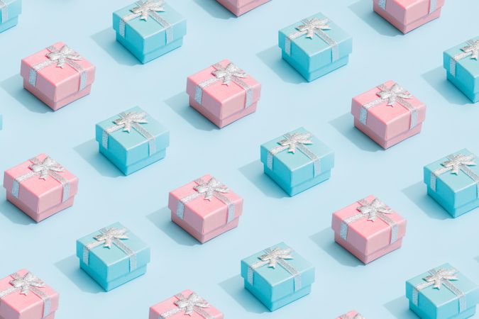 Pastel pink and blue ribbon wrapped presents on baby blue background