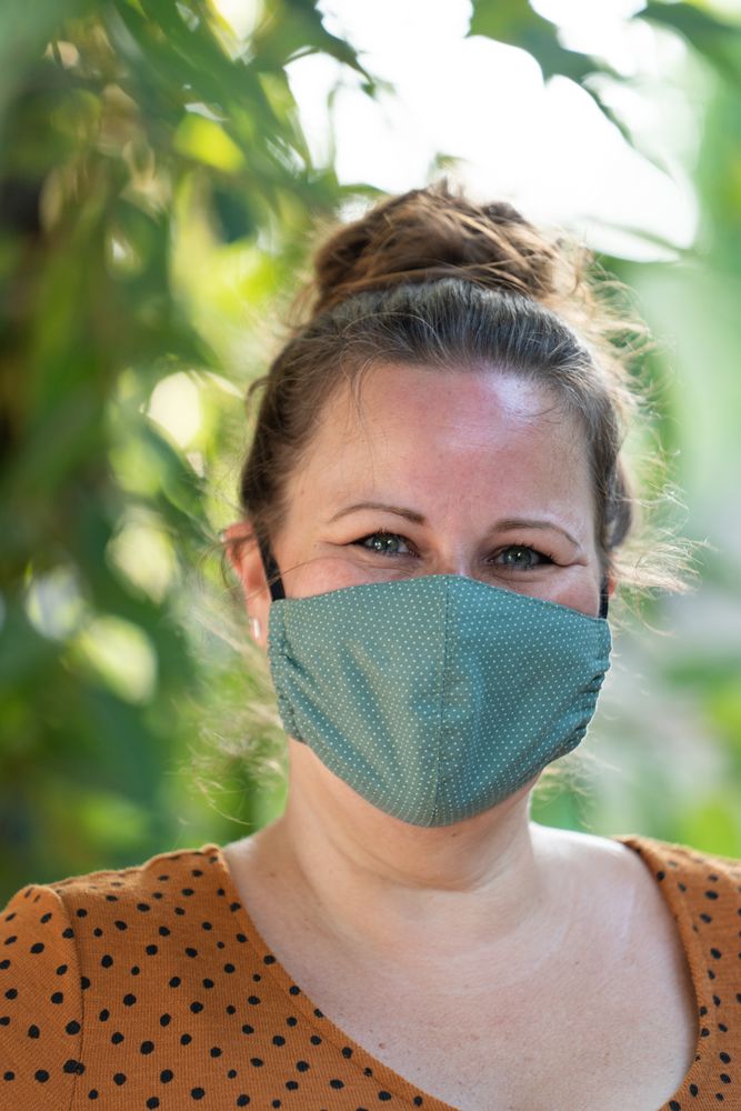 Close up portrait of woman with homemade mask smiling and looking at camera